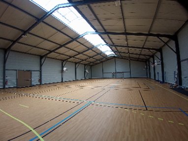 Intérieur d’un gymnase couvert avec terrain multisport.